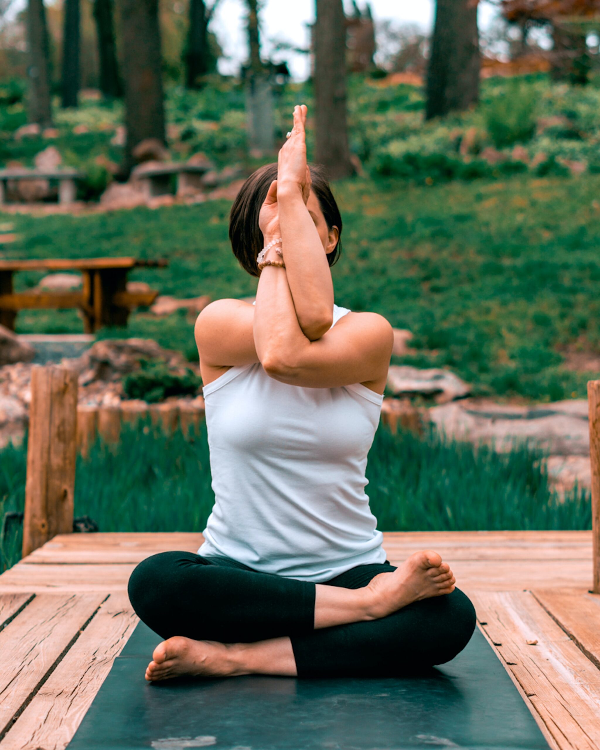 Photo of woman doing seated yoga pose outside. Photo by Erik Brolin on Unsplash.